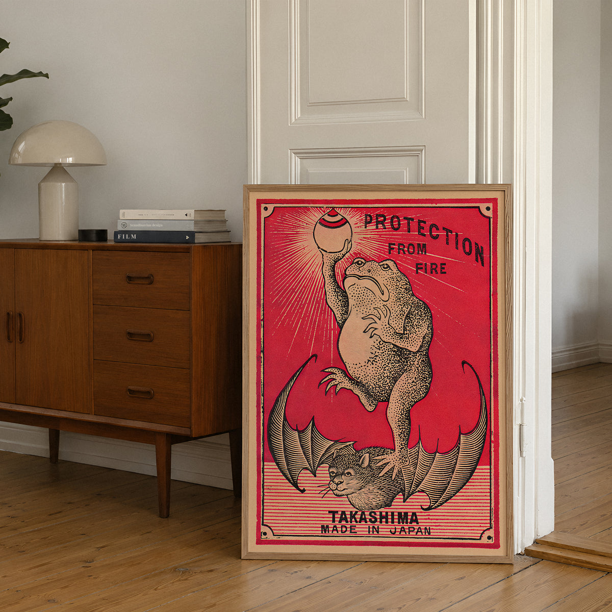 Frog Protection from Fire art print displayed in an interior, featuring a frog and vintage fire-protection graphics.